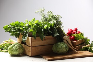 Different fresh herbs, radishes and cabbage on white table