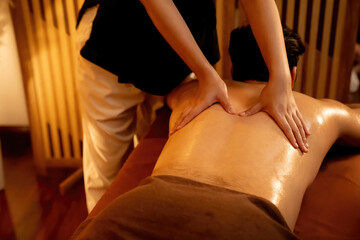 Obraz premium Caucasian man customer enjoying relaxing anti-stress spa massage and pampering with beauty skin recreation leisure in warm candle lighting ambient salon spa at luxury resort or hotel. Quiescent