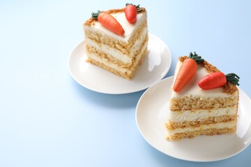 Pieces of delicious carrot cake on light blue background, closeup. Space for text