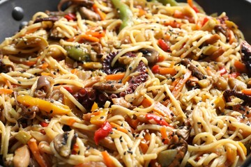 Stir-fry noodles with sea food and vegetables in wok, closeup
