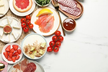 Different tasty food served for brunch on white marble table, flat lay. Space for text