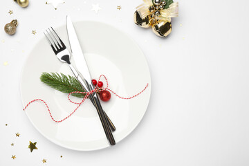 Christmas table setting with plate, cutlery and festive decor on white background, flat lay. Space for text