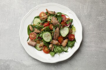 Delicious fresh tuna salad on grey table, top view
