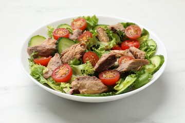 Delicious fresh tuna salad on white table, closeup