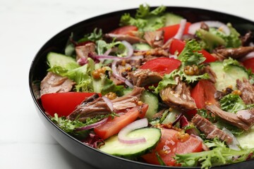 Delicious fresh tuna salad on white table, closeup