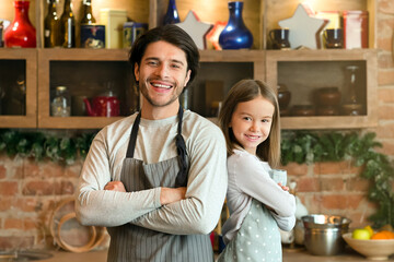 Happy Young Dad And Little Daughter In Aprons Posing In Kitchen While Cooking Healthy Food Together, Free Space