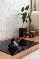 Brewing coffee in a modern kitchen with a stylish pot and greenery on the countertop