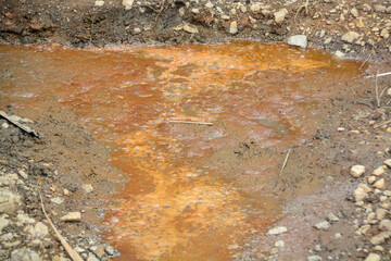 The orange water may be a sign of pollution or environmental damage.