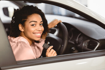 Buying New Car. Happy Lady Doing Test Drive Posing With Auto Key Sitting In Automobile In Dealership Center. Selective Focus