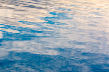 Close up macro photo of waves on water surface blurred ripples. Transparent defocus blue and white...