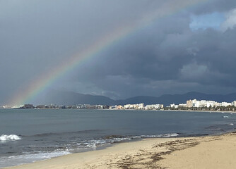 Rainbow over the sea and over the city of Palma. Arenal beach. Mallorca island. Spain.