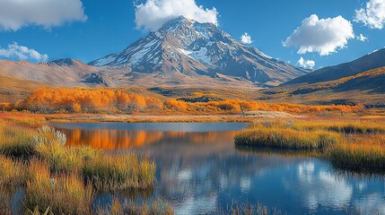 Fototapeta premium A mountain stands tall in the backdrop while a lake gleams in the foreground Grass blankets the landscape in the foreground