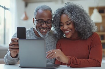 A joyful senior African American couple using a laptop together at home, smiling and enjoying technology