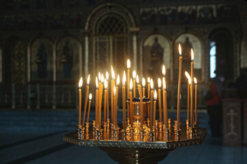 Lighted candles on the golden stand in Russian Orthodox Christian cathedral