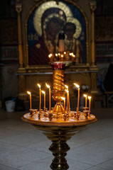 Lighted candles on the golden stand in Russian Orthodox Christian cathedral