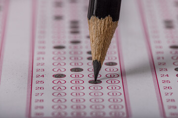 Exam, a hand taking an exam with a pen on an optical reader. Exam, an idea concept. Anxiety about...