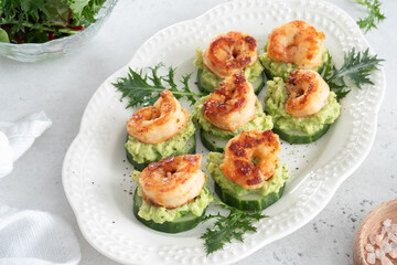 A plate of shrimp and cucumber bites with a garnish of parsley