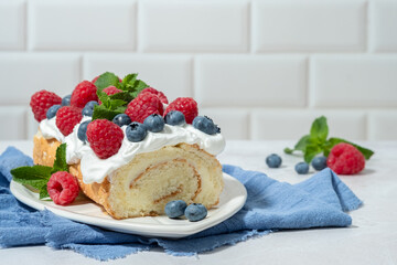 A slice of cake with blueberries and raspberries on top