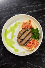 Savor a Grilled Steak served with Tomato Salsa and Green Sauce, beautifully presented