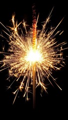 A single sparkler burns brightly against a dark background, creating a dazzling display of light and sparks.