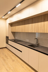 Modern apartment interior showcasing sleek kitchen design with minimalist cabinetry and elegant countertops in a newly renovated space