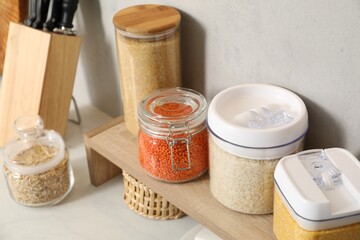 Different types of cereals and legumes in containers on light table