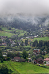 Misty morning in Vorokhta village with scenic view of Carpathian hills and fog-covered mountains