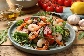 Delicious shrimp salad with vegetables on wooden table, closeup