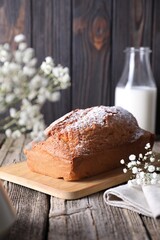 Tasty sponge cake with powdered sugar on wooden table