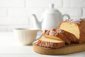 Freshly baked sponge cake on white wooden table, closeup. Space for text