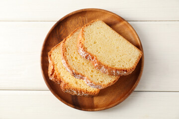 Freshly baked sponge cake on white wooden table, top view