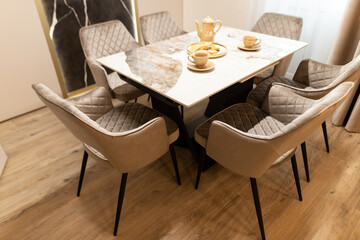 Elegant apartment dining area showcasing chic interior design with a modern table and stylish chairs, perfect for social gatherings