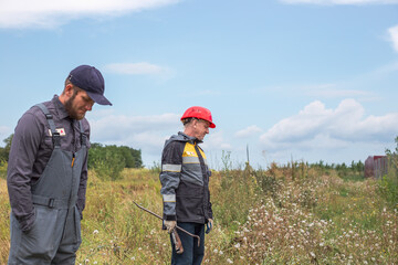 Workers in overalls outdoors in rural areas. Working professions. Water supply specialists.