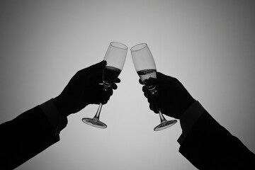 Silhouette of hands toasting with champagne glasses in celebration