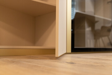 Transforming an apartment with modern interior design: A close-up view of sleek cabinetry and warm wooden flooring in an inviting environment