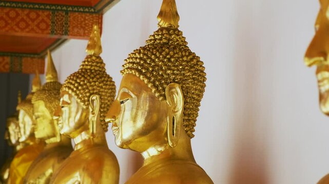 Row of golden Buddha statue in Wat Pho Temple Complex in Bangkok city, Thailand, Asia. Temple of the Reclining Buddha. Popular tourist landmark
