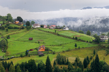 Misty morning in Vorokhta village with scenic view of Carpathian hills and fog-covered mountains