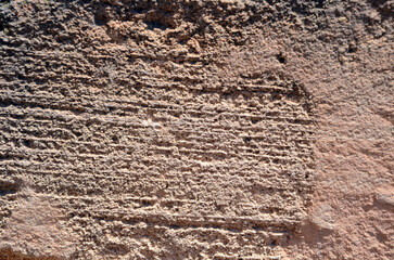 Background. Uneven stone surface with chiaroscuro, shallow stripes and pinkish tint. Majorca Island. Spain.