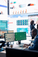 Chief financial officer reviews cost and revenue numbers next to a green screen, working on data management study for future improvement. Accountant ensures organizational success.