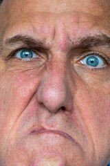 Funny, angry and weird face expression of a close up man.