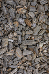 Close-up of grey and brown textured rocks forming a natural surface background. Concept of geology, earth materials, construction, and nature patterns