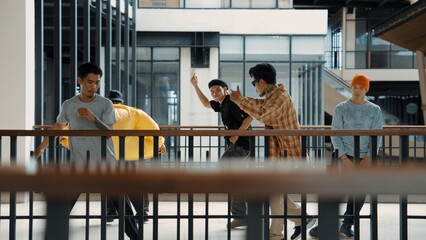 Multicultural hipster group walking while dancing at modern corridor. Attractive break dance team happy and joy while moving to hip-hop music. Active. Site view. Outdoor sport 2024. Hiphop.