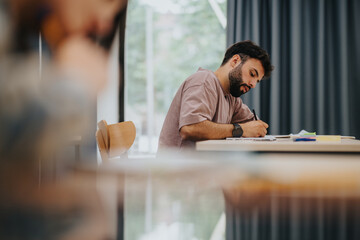 A student intently writing in a classroom, highlighting focus and education.