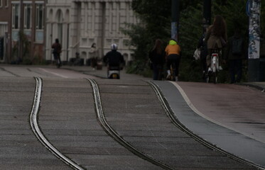 Bicyclists riding away on tramway tracks during morning commute - 2