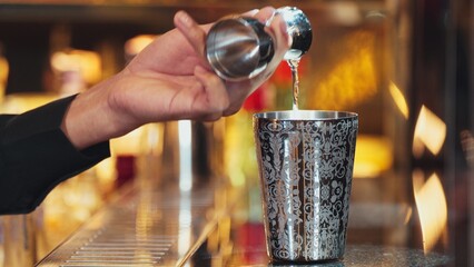 Closeup mixing hand bartender holding jigger to measure sugar salt all of ingredients into shaker preparation at bar. Special refresh drink showcasing nightlife mixology inviting warm light. Vinosity.
