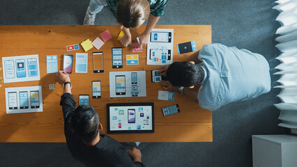 Top view of smart Ui designer brainstorming and planning about Ux Uo design or mobile interface wireframe design with diverse develop team. Caucasian programer walking and joining meeting.Convocation.
