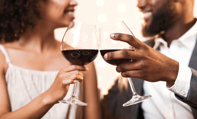 Cheers. Cropped of afro couple celebrating St. Valentine's Day at restaurant, drinking red wine