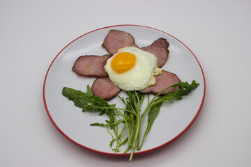 Fried egg with bacon and arugula