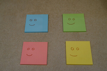 Smileys on yellow, pink, green and blue sticky notes