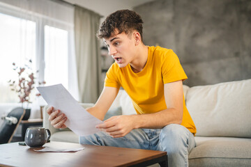 adult young man worried exhausted about expensive bills at home